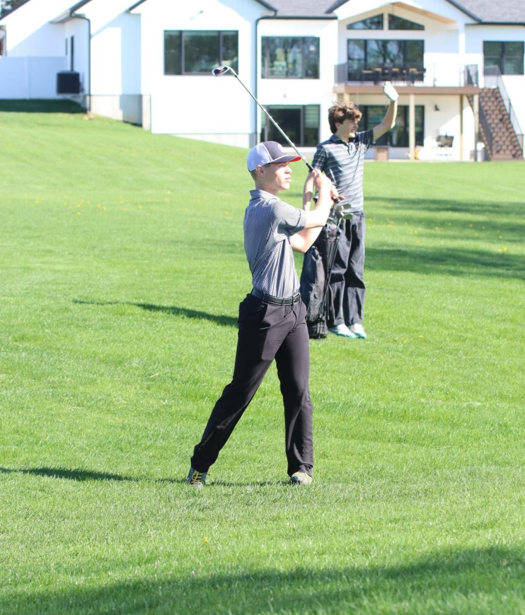 After hitting the ball, senior Evan Dunkel watches as it flies through the air. Dunkel has a nine hole average of 56.00. 