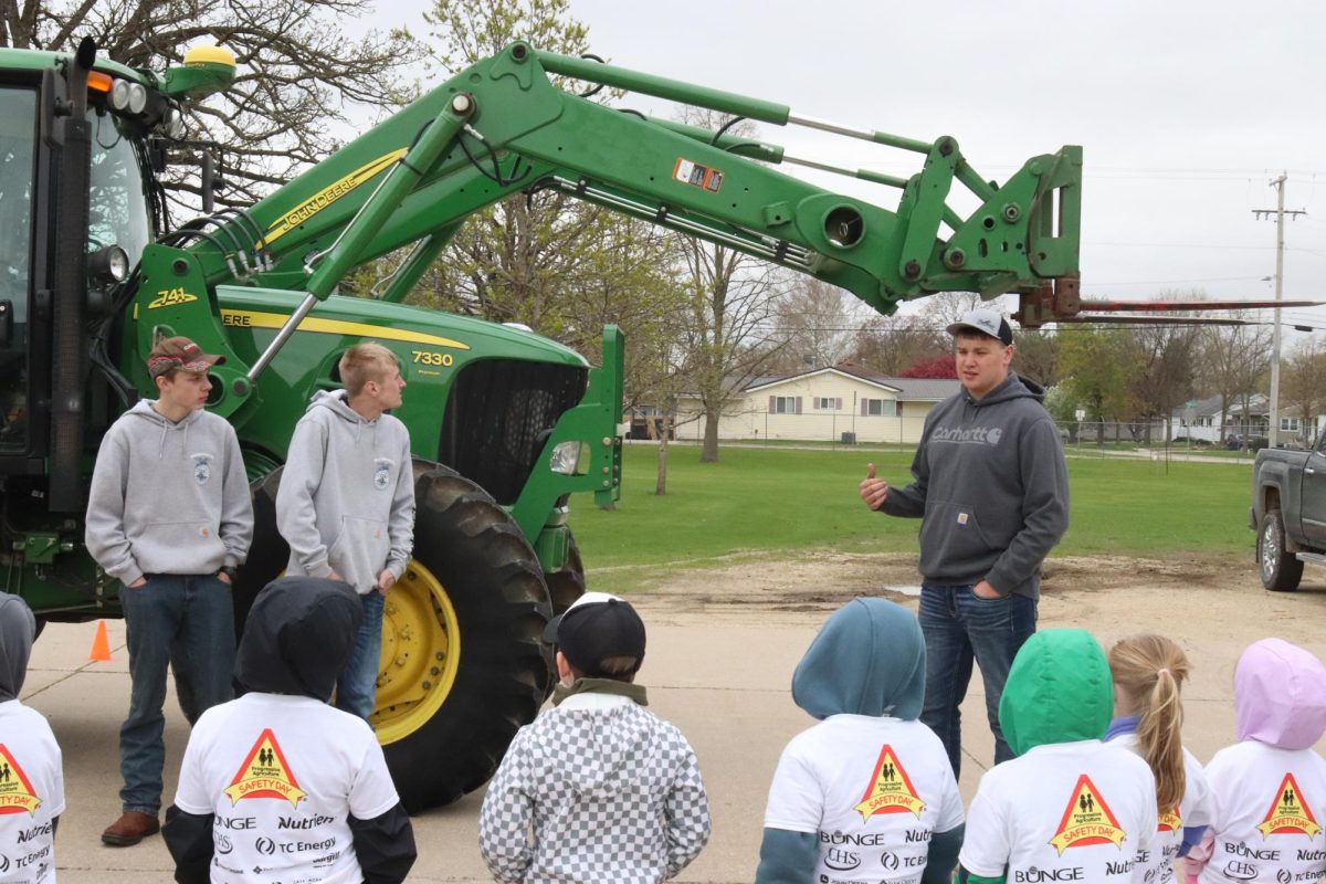 Showing kids the different parts of a tractor, John Wickman (10), Hunter Rave (10), and Blake Ries (11) explain the importance of being safe around big machinery.