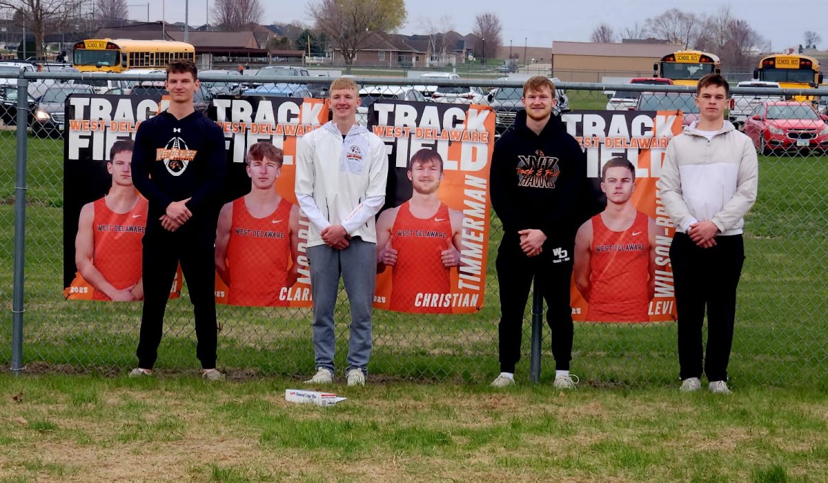 Seth Jackson (12), Clark Morris (12), Christian Timmerman (12), and Levi Wilson-Bries pose in front of their senior posters after qualifying for state. (Photo contributed)