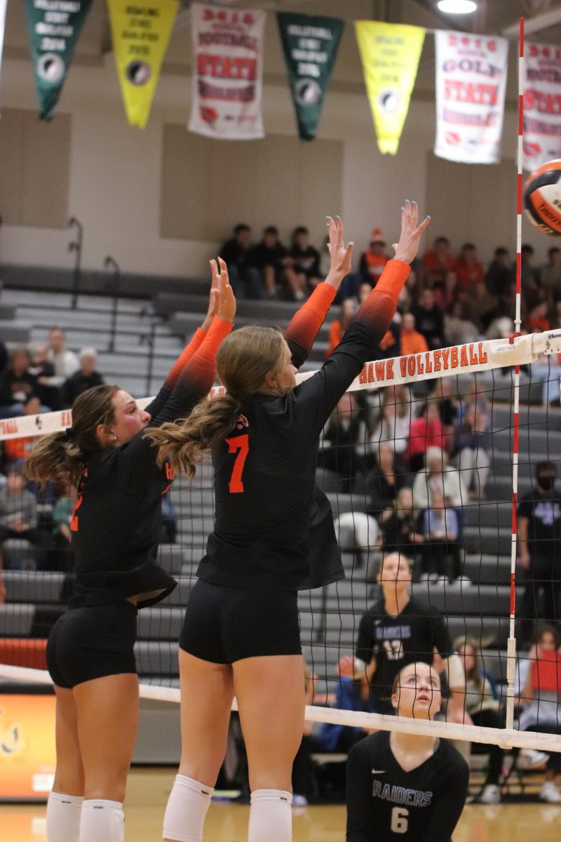 Reading the Williamsburg Raiders' hit, seniors Vedah Langel and Natalie Mensen jump in sync to block the ball.