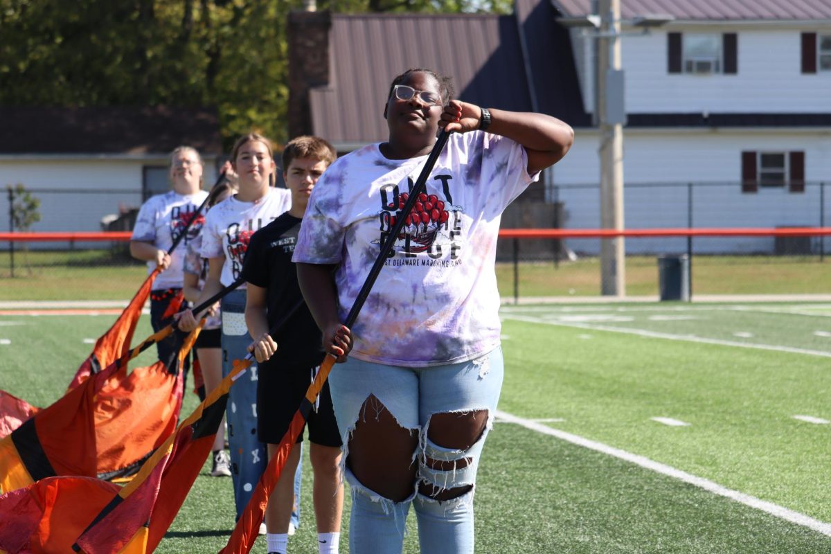 Sophomore Tamara Pittman smiles during the color guard routine at the beginning of the pep rally. 