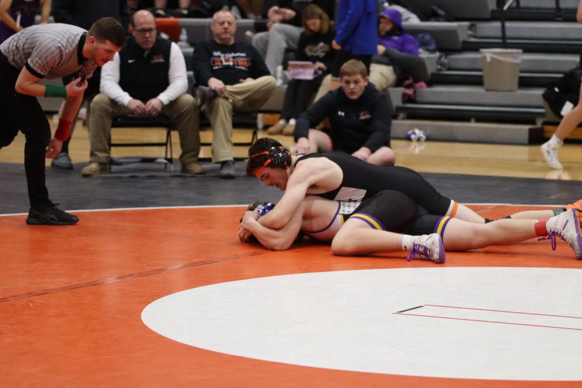 Entering his second match, Cade Fessler (12) works toward the pin. Fessler won against his opponent, 3-0.
