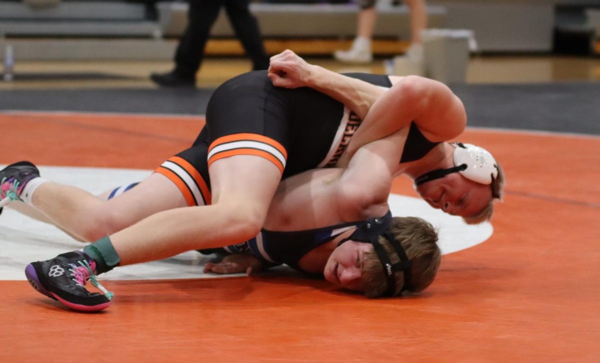 Colby Bahls (9) battles for the win, taking control and pushing his opponent to the mat. He ended the bout with a 17-2 victory. 