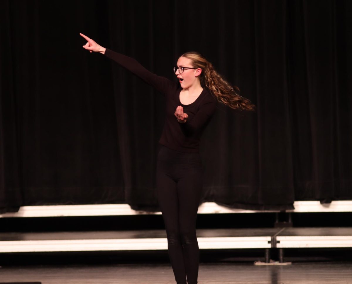 Performing her solo mime at the All State Speech showcase, Claire Hegland (9) points at the moon. Hegland earned the ability to perform her piece at All State.