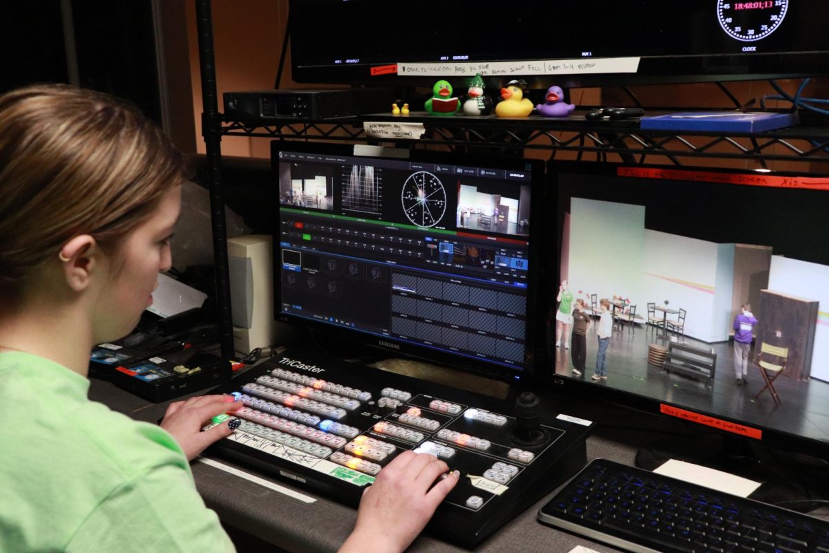 In the light booth, Carleigh Lux (10) works the video during parents' night.