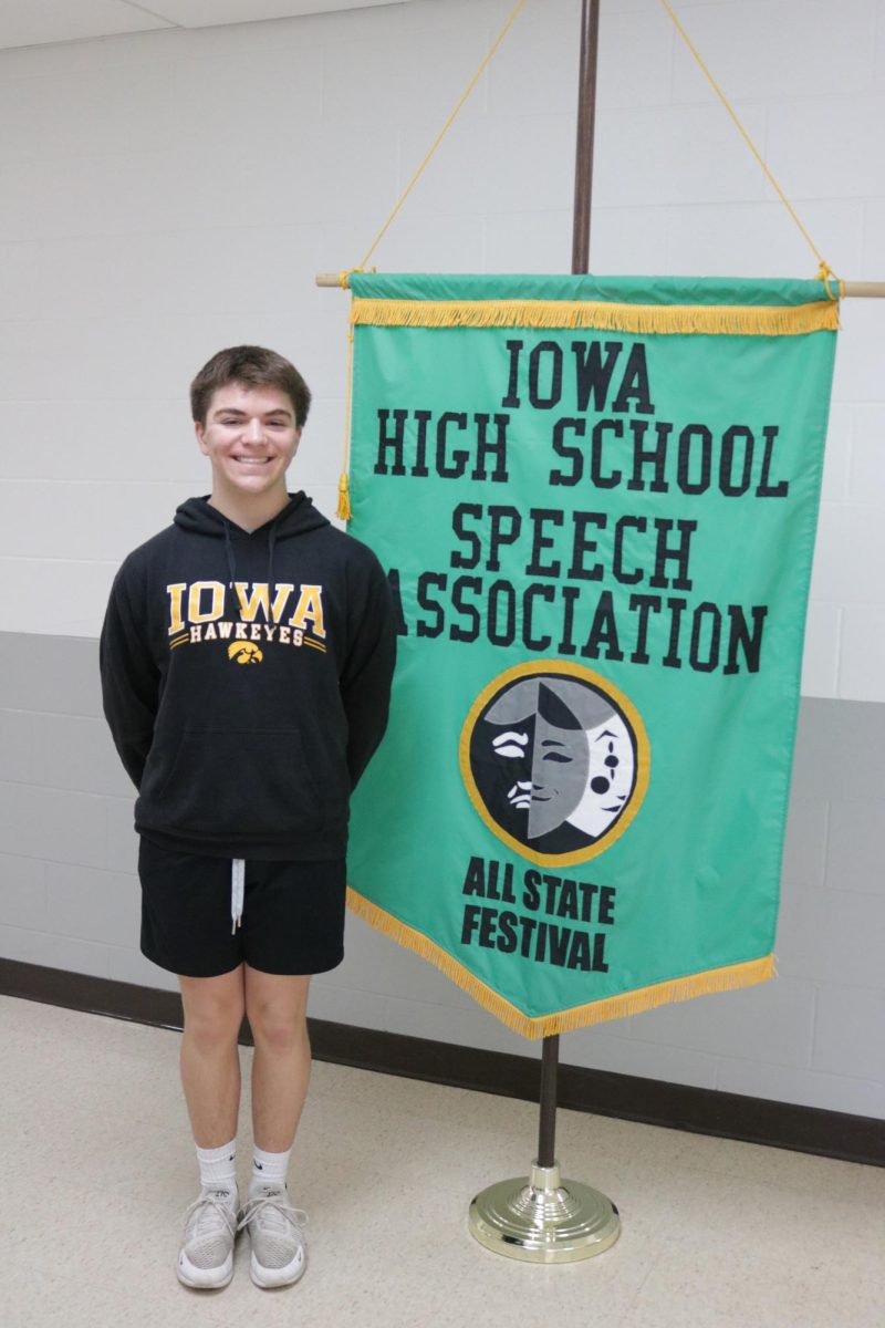 Kaidyn Robbins stands proudly by the All-State Banner.