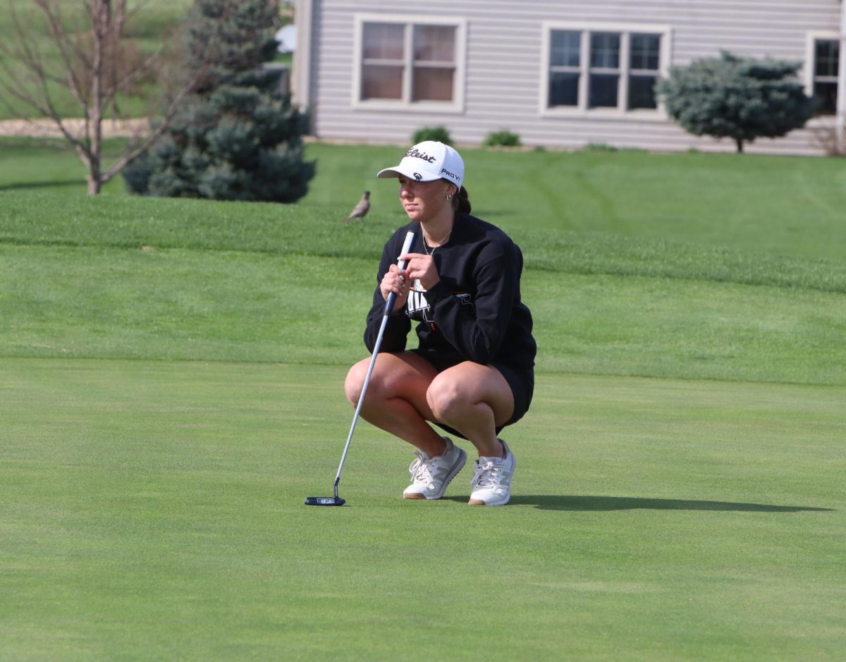 Putting the ball on the green, Malorie Putz (12) focuses on the hole.