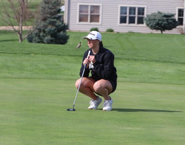 Putting the ball on the green, Malorie Putz (12) focuses on the hole.