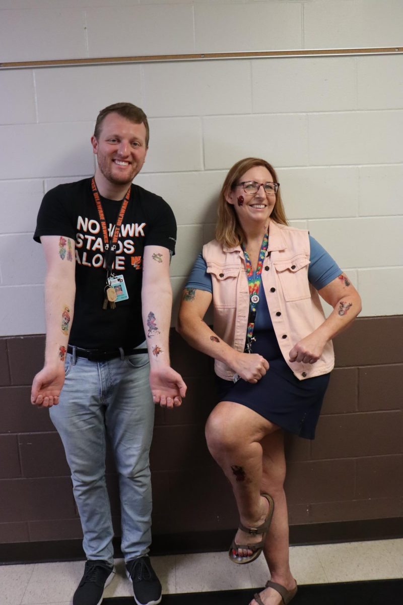 Smilling, teachers Jonathan Green and Jackie Hawkins-Keck enjoy their new tattoos.