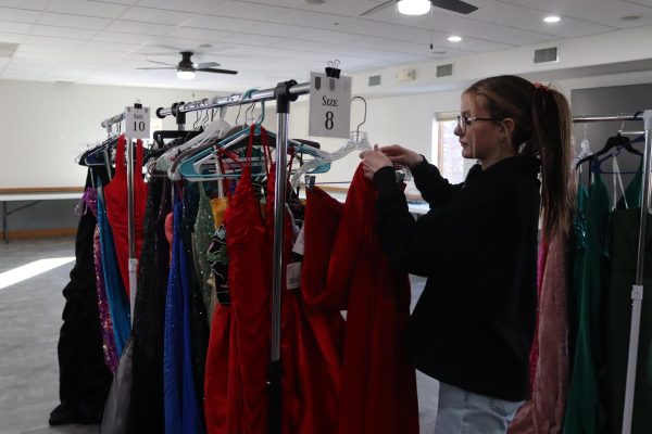 Freshman Claire Hegland hangs up dresses in preparation for the sale